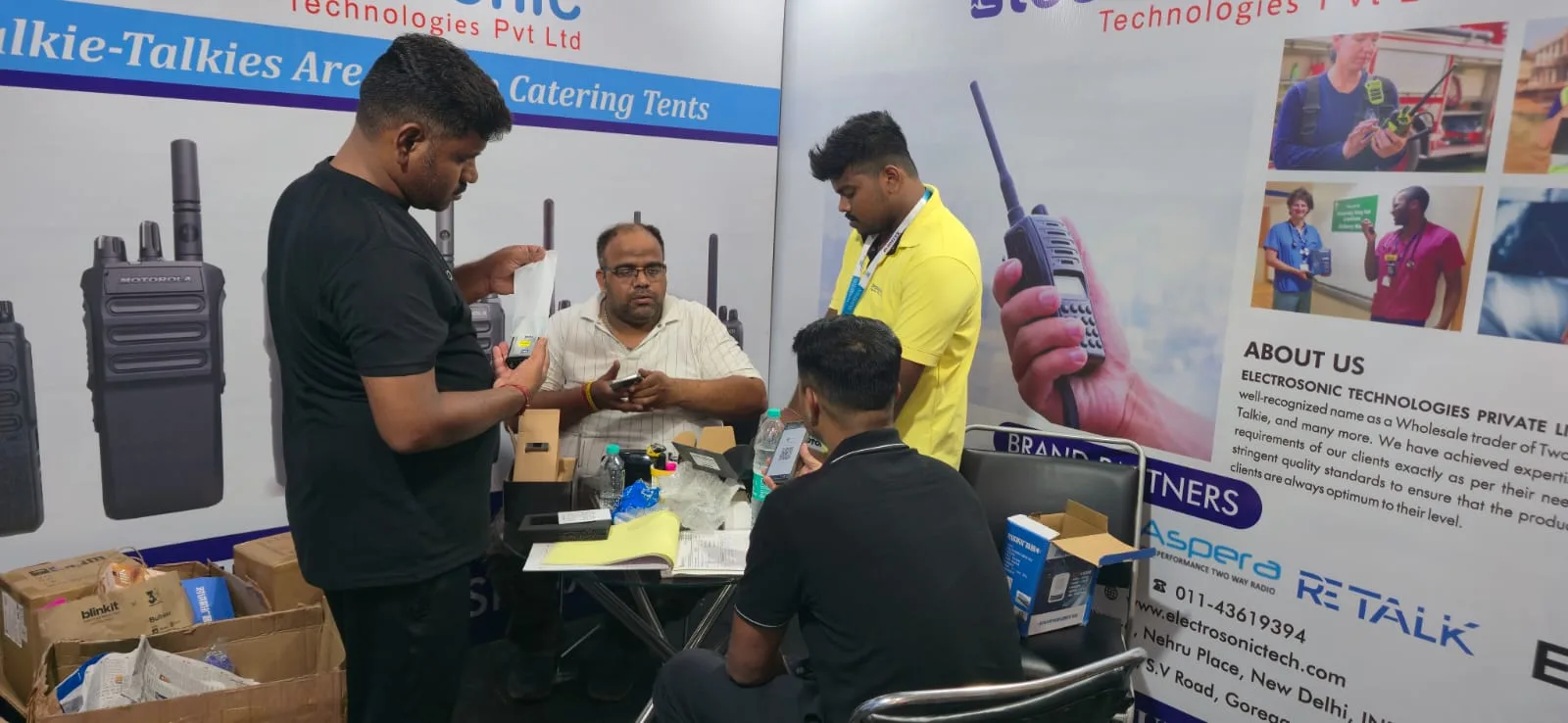 Electrosonic booth team preparing radios and brochures at HMTEX Expo Ludhiana
