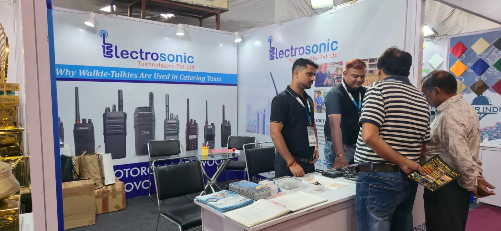 Electrosonic display counter with walkie talkies and visitor discussion at HMTEX