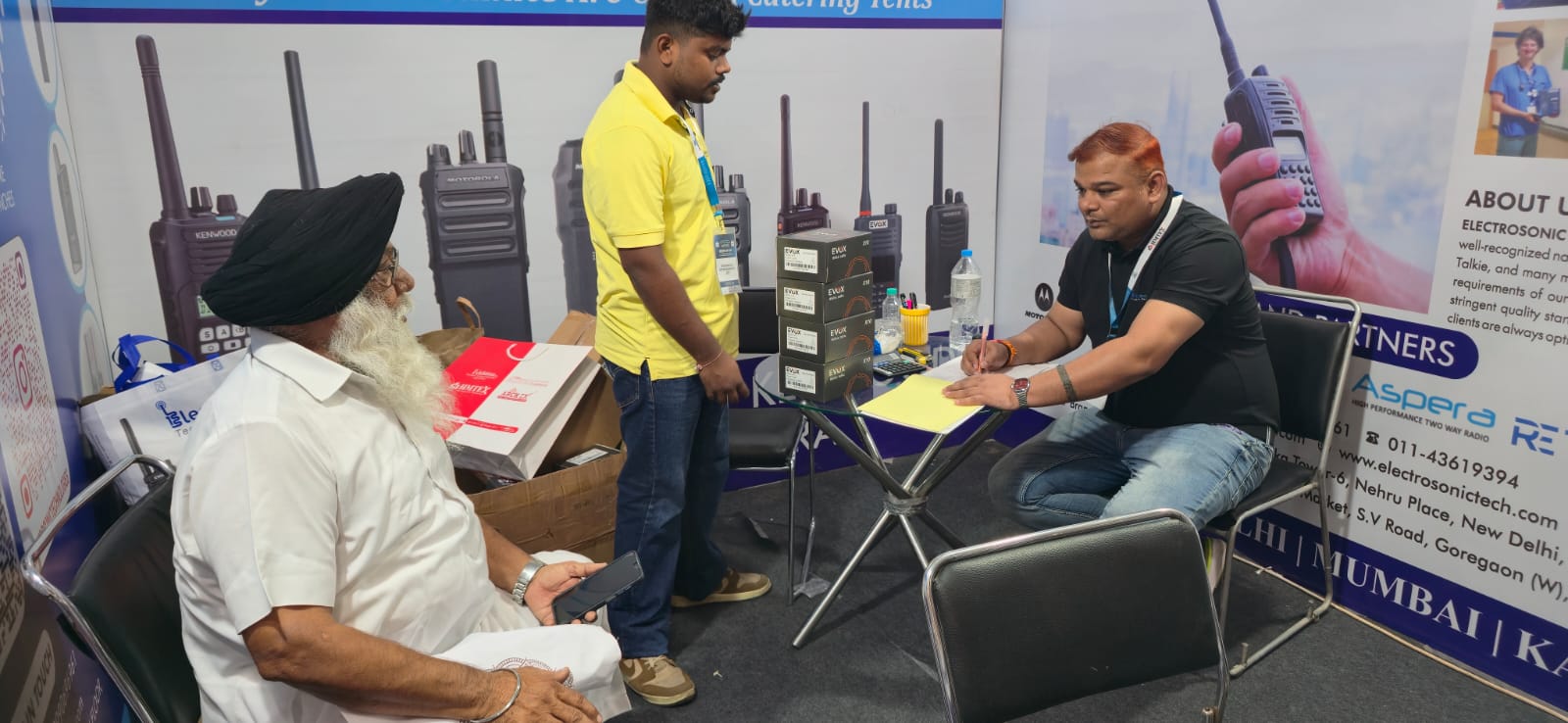 Seated visitor consultation at the Electrosonic booth in Ludhiana