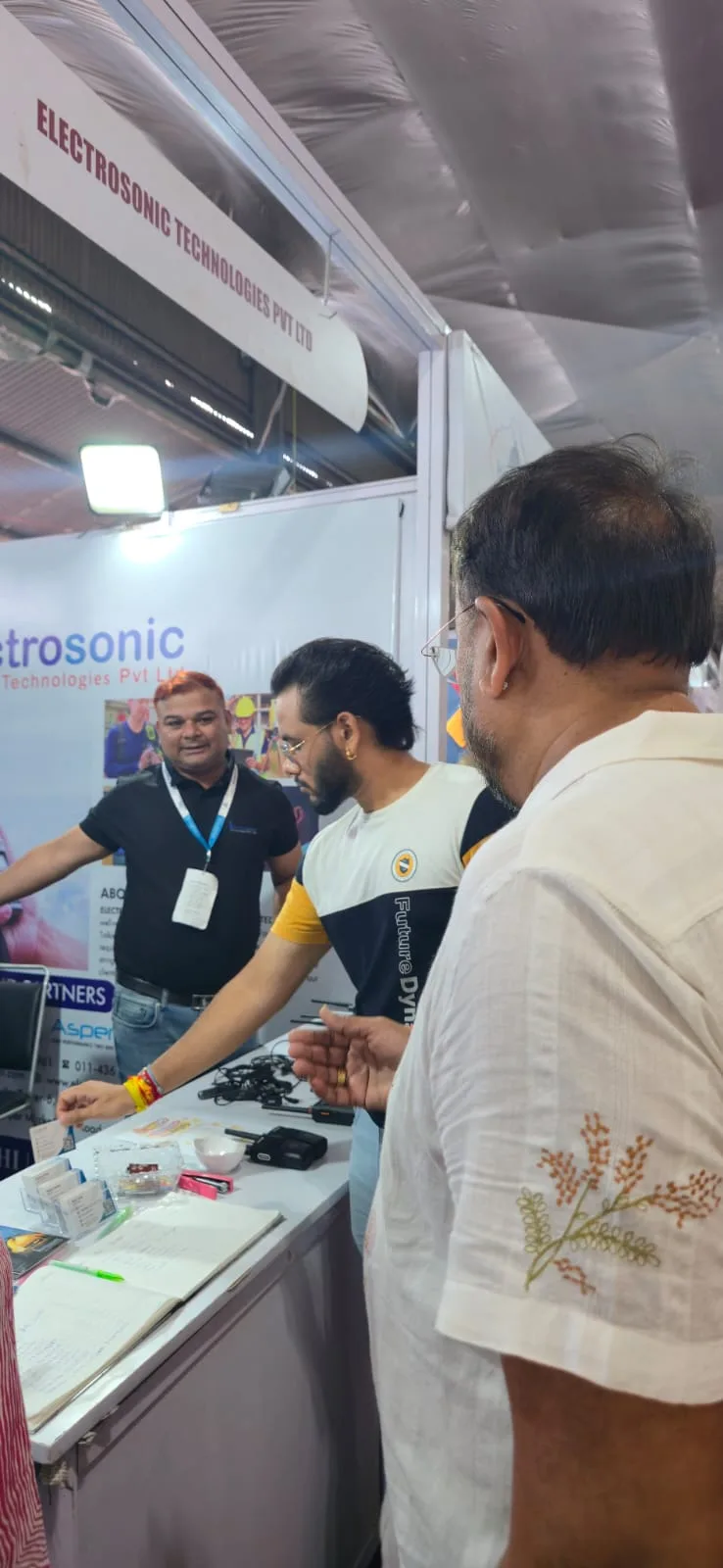Visitors discussing communication products at the Electrosonic booth in Ludhiana